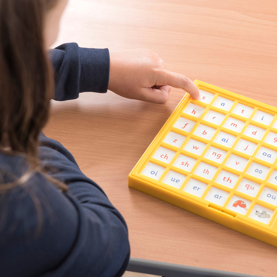 Child pressing a tile on the Jolly Phonics Chatter Board to hear a phonics sound.