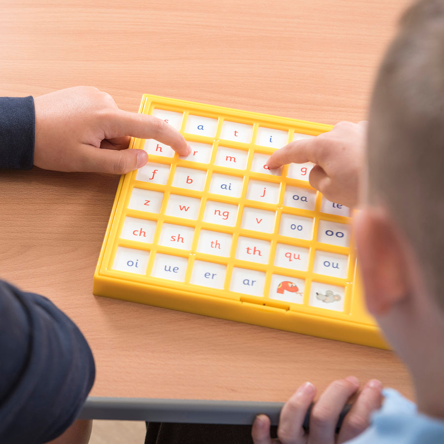 Child pressing a tile on the Jolly Phonics Chatter Board to hear a phonics sound.