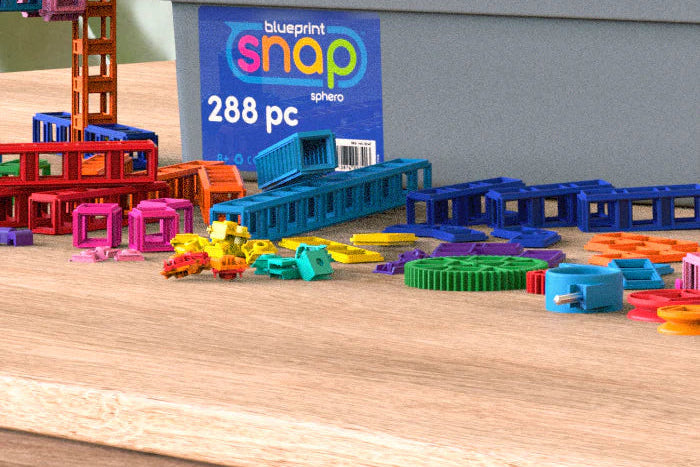 Colourful toy building blocks with a 'blueprint snap' packaging in the background.